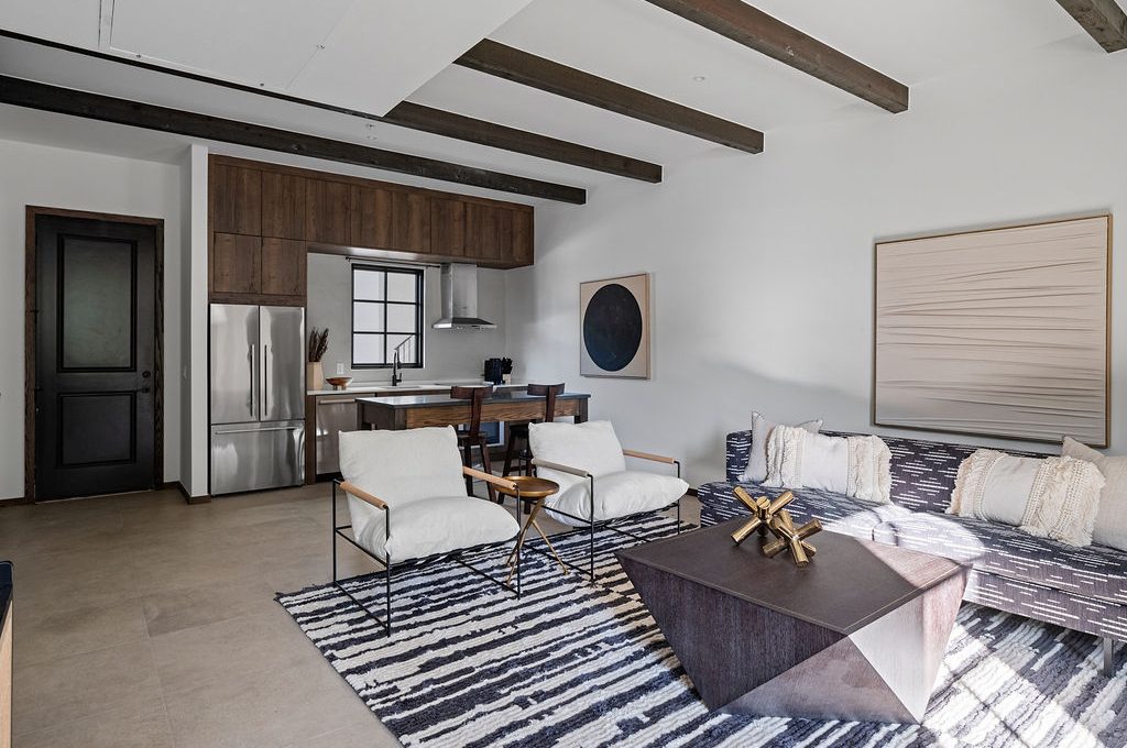 a living room filled with furniture and a kitchen