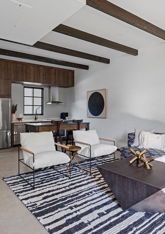 a living room filled with furniture and a kitchen