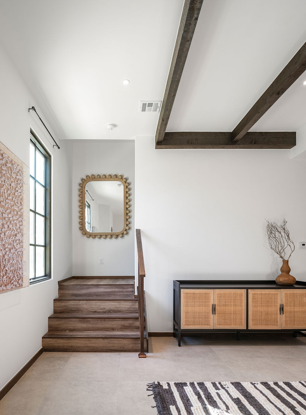 a living room with a wooden floor and a large mirror