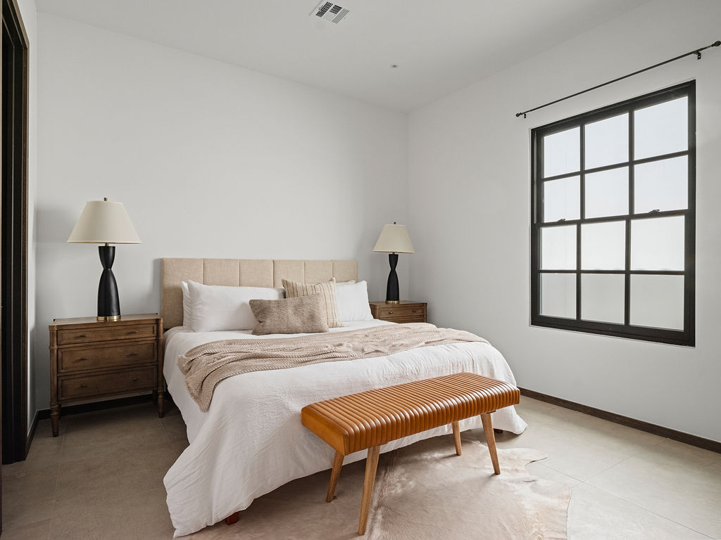 a bedroom with a bed, chair and a lamp